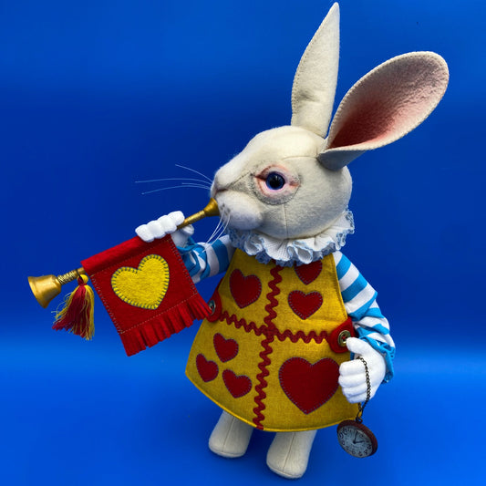 Toy rabbit with a heart-shaped bag and clock on a blue background